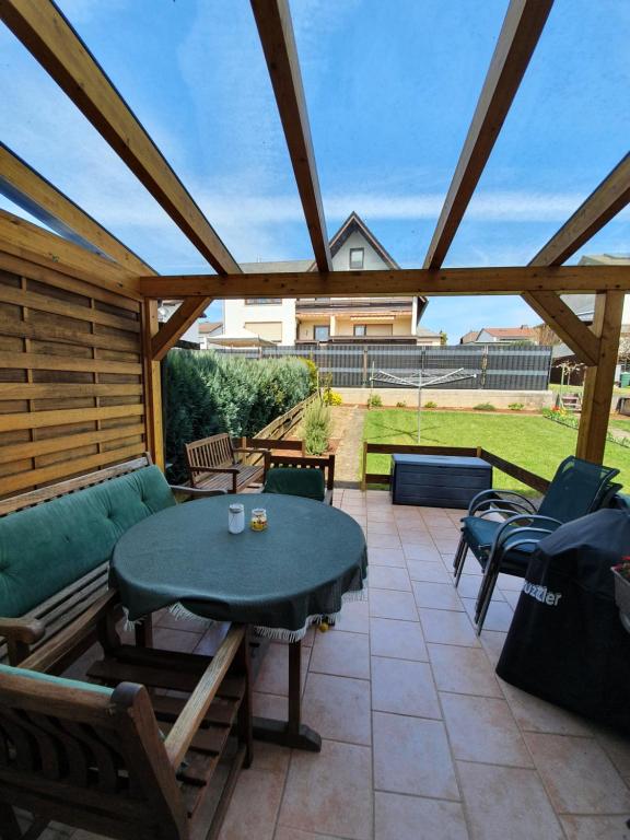 eine Terrasse mit einem grünen Tisch und Stühlen in der Unterkunft Ferienwohnung Wölbert in Altendiez