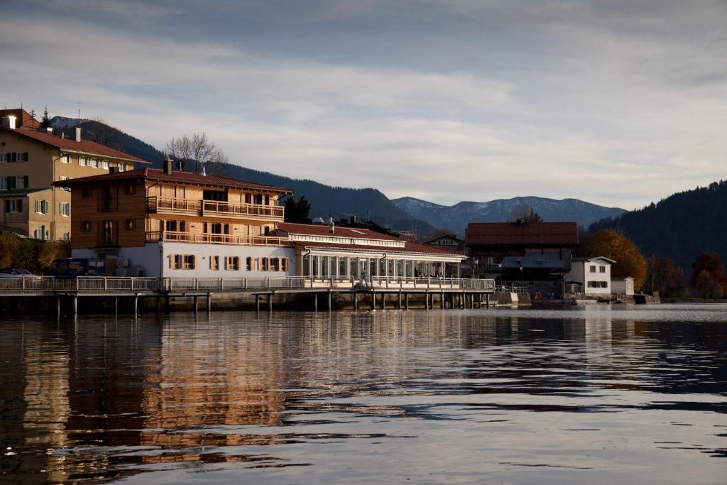 a building on a dock next to a body of water at Clubhaus Bachmair Weissach in Tegernsee