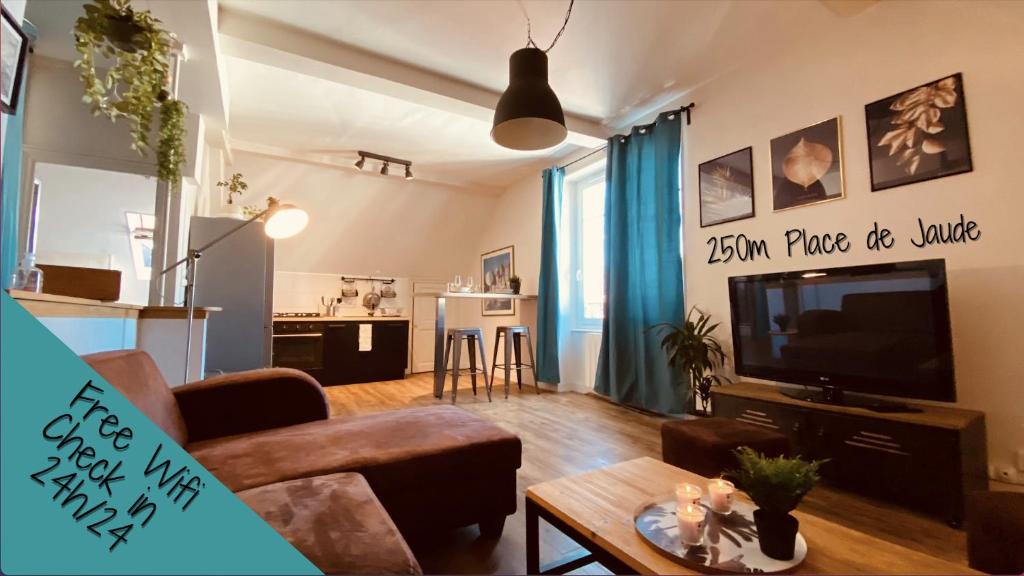 a living room with a couch and a tv at Under Roof in Clermont-Ferrand