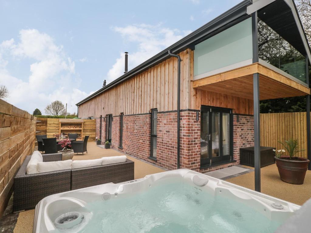 a bath tub on the patio of a house at Lugg View in Hereford
