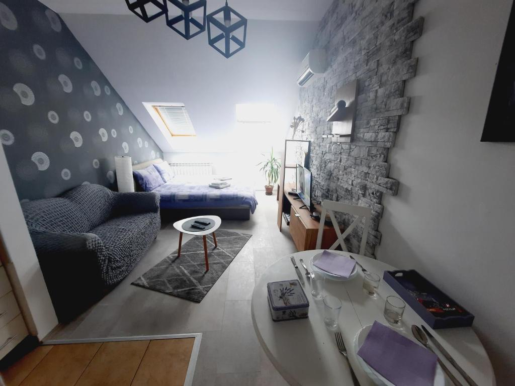 ein Wohnzimmer mit einem Sofa und einem Tisch in der Unterkunft Apartment Centrum - Free private parking in Novi Sad