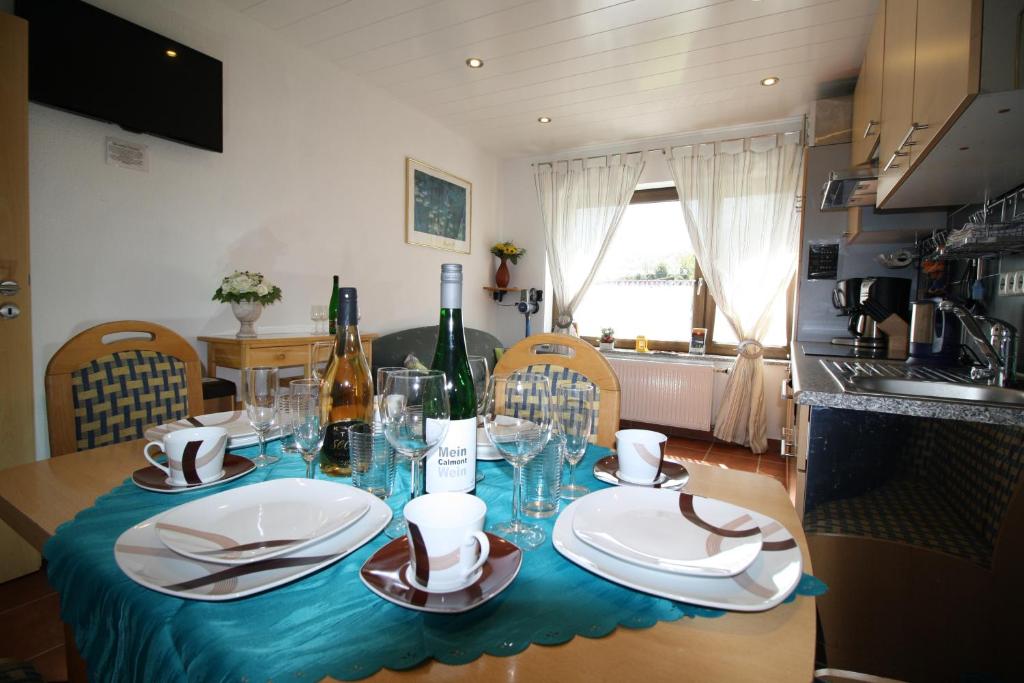 a table with a blue table cloth and wine bottles at Komfort Ferienwohnung FEWO74-1 in Bremm