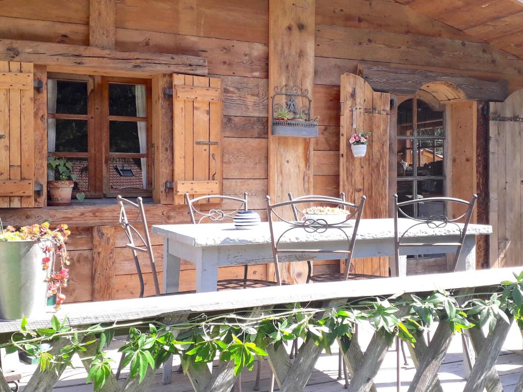 a table and chairs on the porch of a cabin at Charmant Mazot in Saint-Gervais-les-Bains