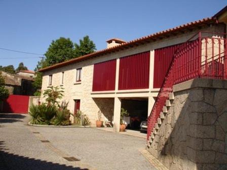 een rood-wit gebouw met een garage bij Casa Dos Tinocos in Braga