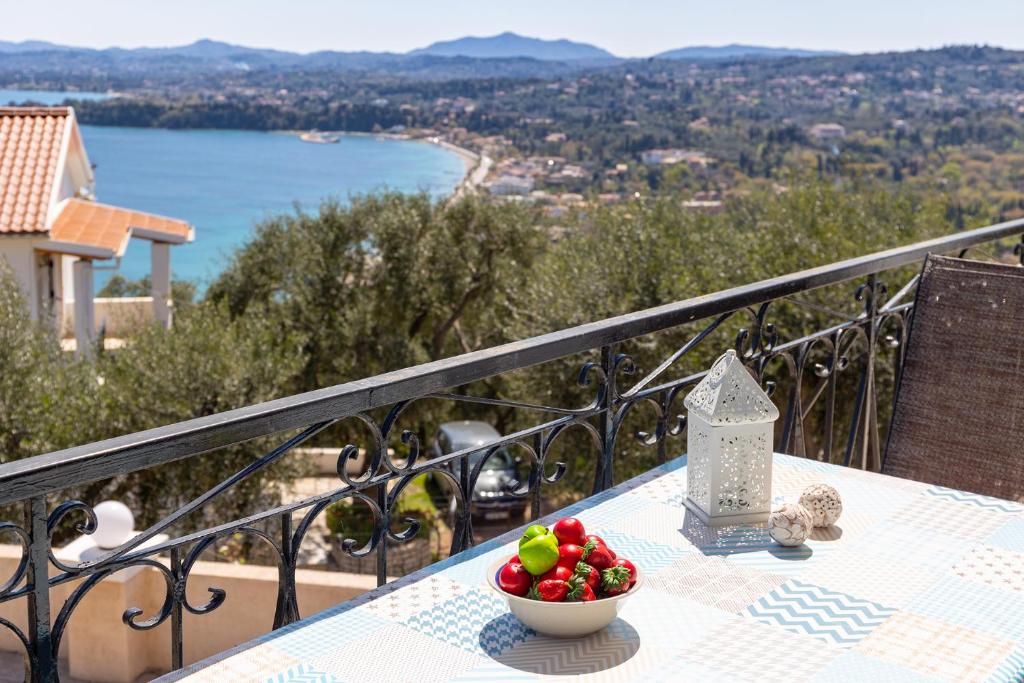 a bowl of fruit on a table on a balcony at Katerina Horizon Apartments by Konnect - 1,8km from Ipsos beach in Ipsos