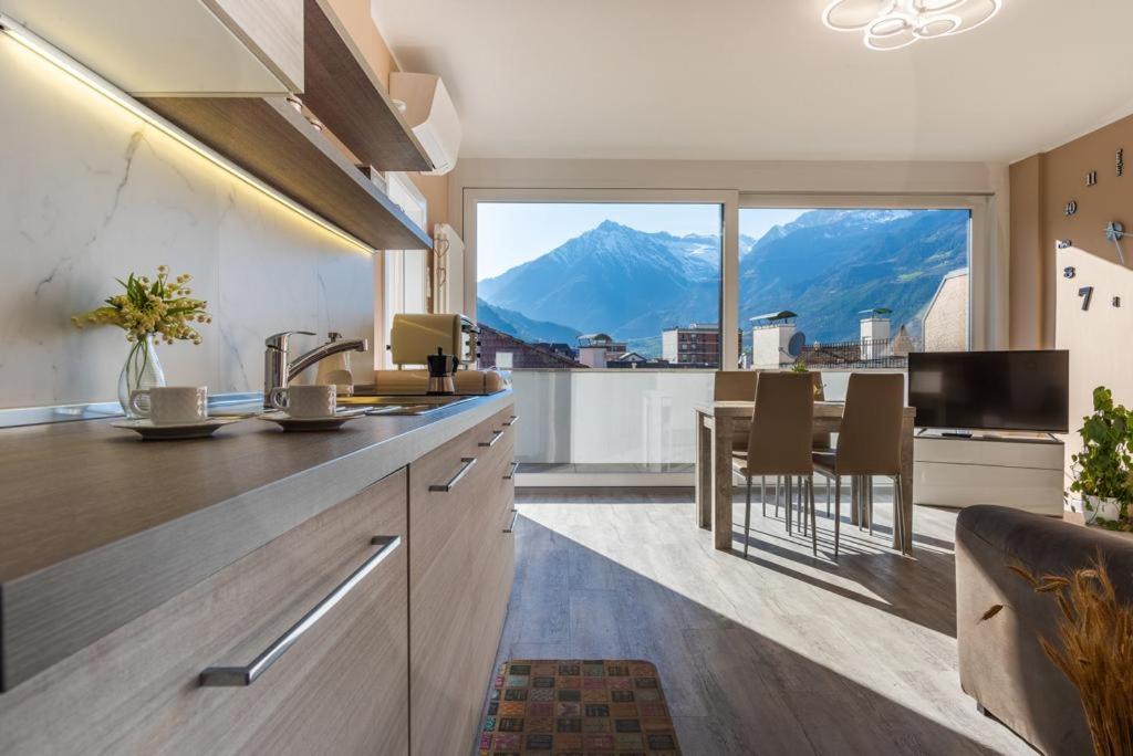 a kitchen with a large window and a table with chairs at Dolce vista in Merano