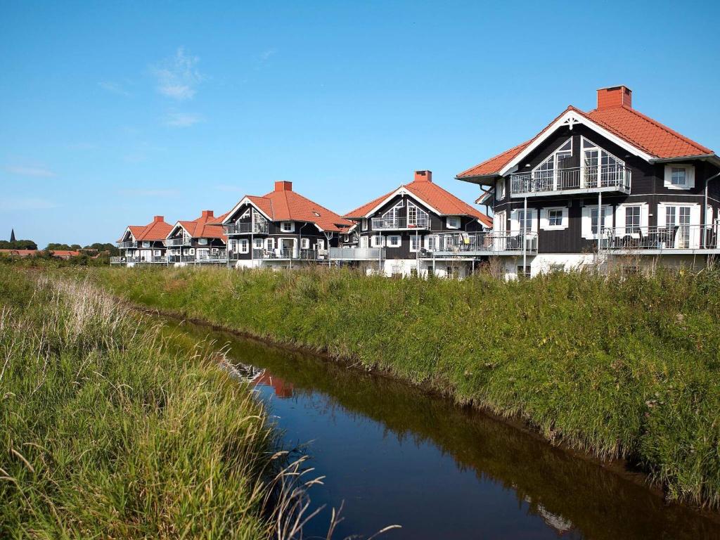 una fila de casas junto a un río en 5 person holiday home on a holiday park in Bogense en Bogense