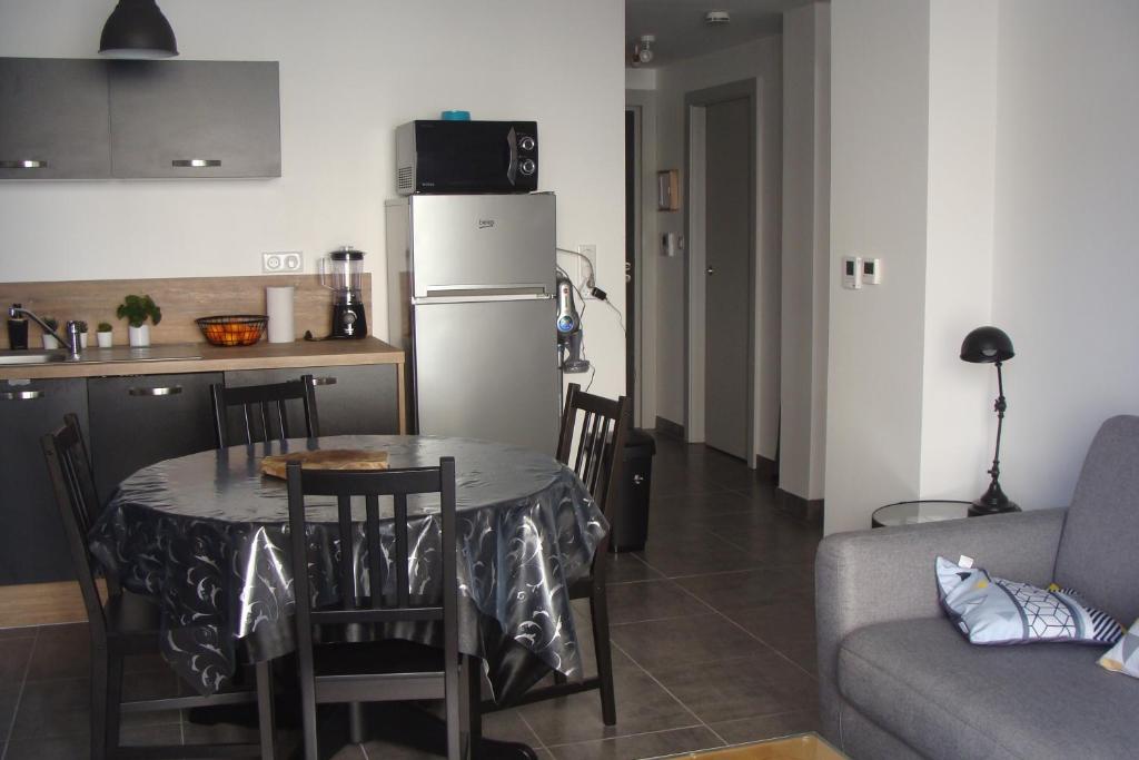 ein Wohnzimmer mit einem Tisch und einer Küche in der Unterkunft au bord du lac in Gérardmer