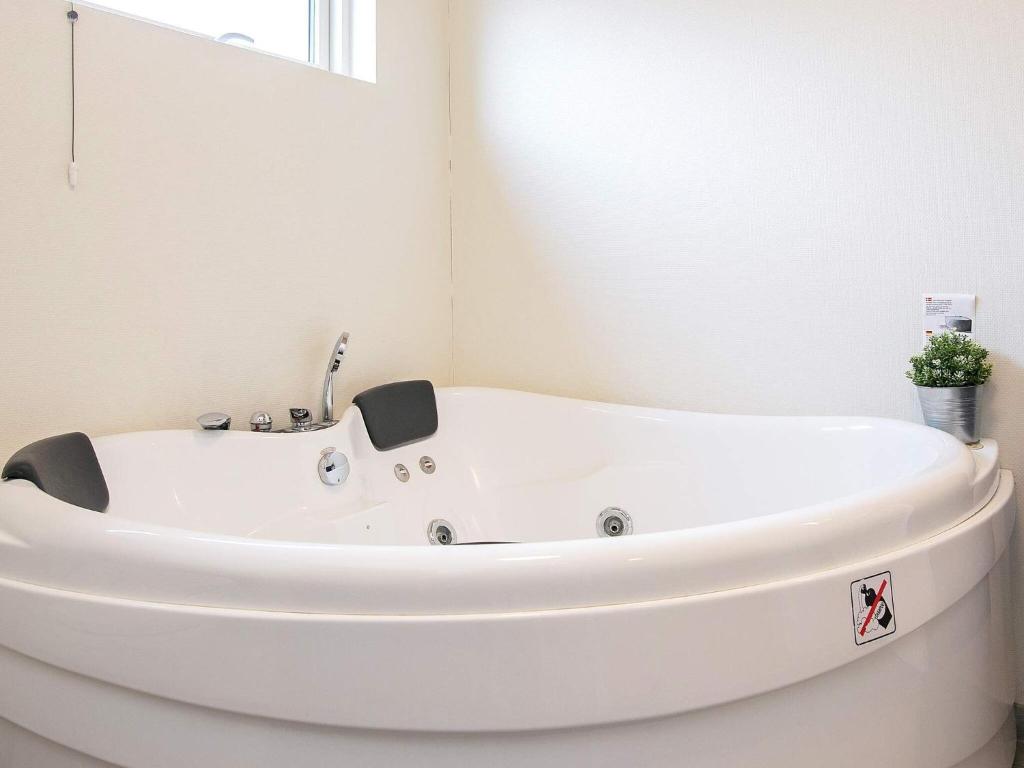 a white bath tub in a bathroom with a window at 6 person holiday home in V ggerl se in Marielyst