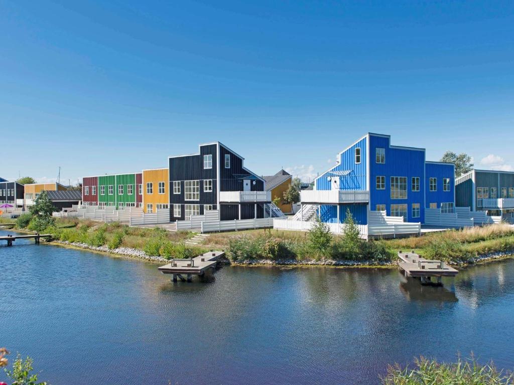 een rij kleurrijke gebouwen naast een rivier bij 7 person holiday home on a holiday park in Ebeltoft in Ebeltoft
