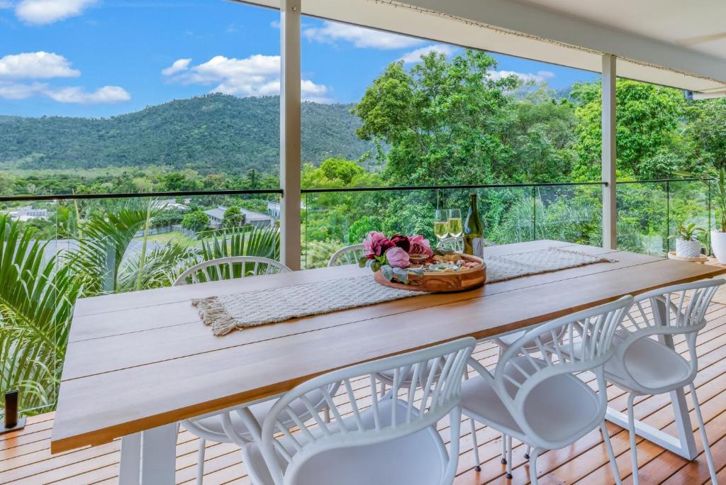 a table and chairs on a balcony with a view at Airlie Abode in Airlie Beach