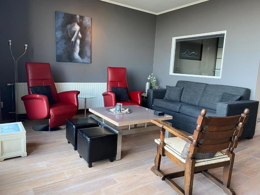 a living room with a couch and red chairs at Hello Zeeland - Appartement Port Scaldis 01-001 in Breskens