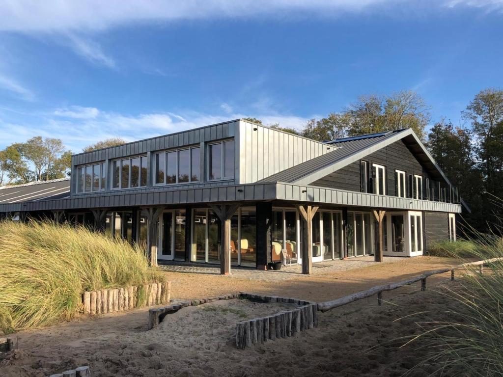 een huis op het strand met veel ramen bij Duinappartementen Schoorl in Schoorl