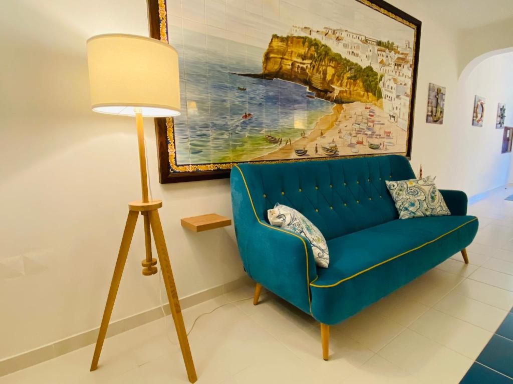 a blue couch in a living room next to a lamp at Quinta das Andorinhas in Carvoeiro