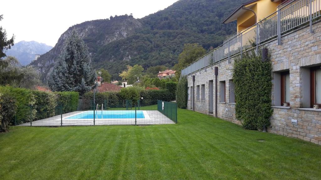 un patio con piscina al lado de un edificio en New Eleven Apartment on Como Lake, en Oliveto Lario