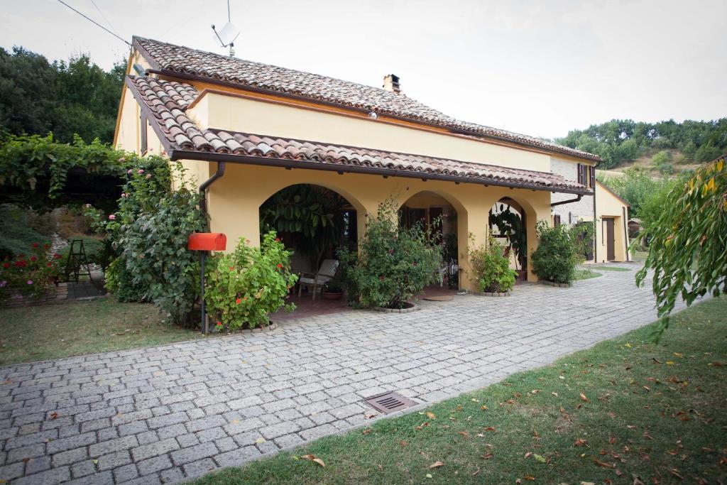 een huis met een bakstenen patio ervoor bij B&B Salvarosa in Fano