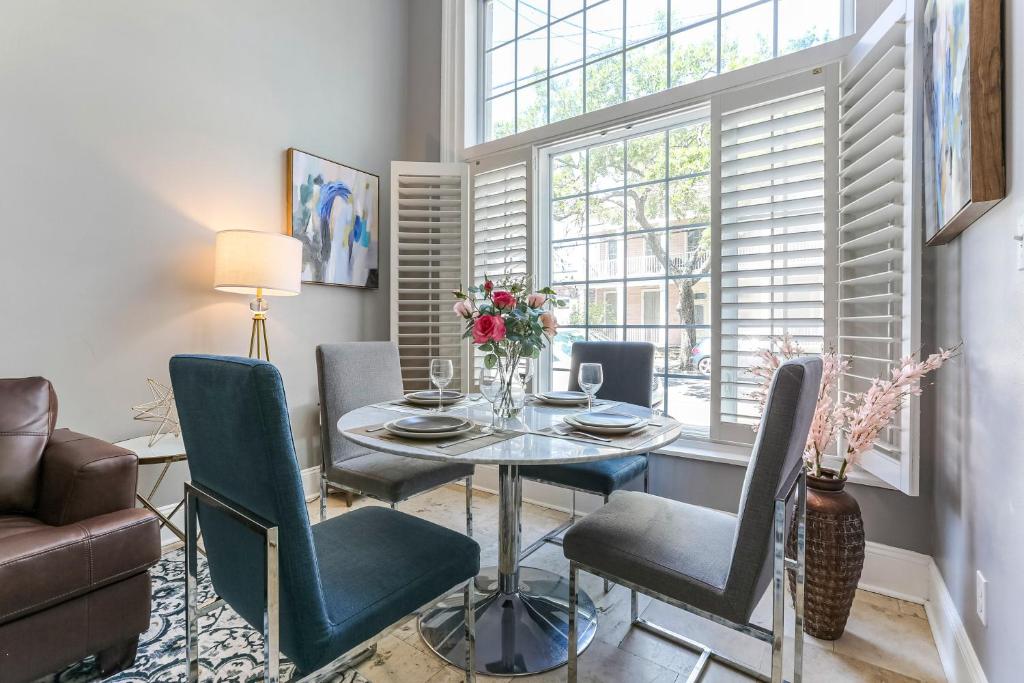 uma sala de jantar com uma mesa e cadeiras e uma janela em Hosteeva Modern Condo Near Magazine St & Close to FQ em Nova Orleans