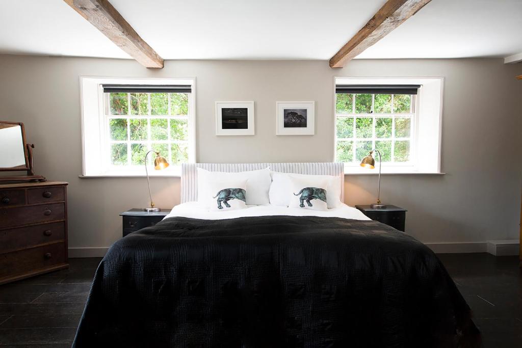 um quarto com uma cama grande e 2 janelas em The Ram Inn em Lewes