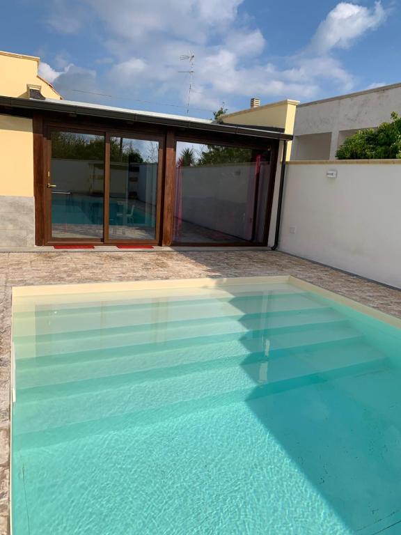 una piscina di fronte a una casa di Appartamento in villa con piscina a 700m dal mare a Lendinuso