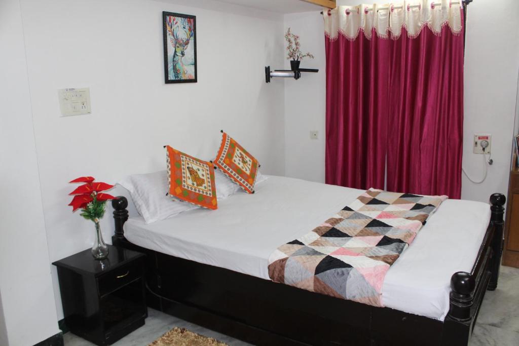 a bedroom with a bed with a red curtain at FriendlyStay at Madanandapuram in Chennai