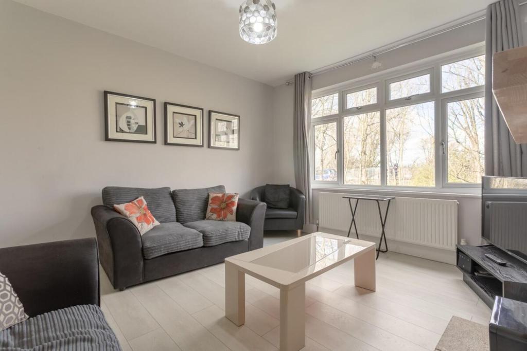 a living room with a couch and a table at Modern 2 Bedroom Apartment in Morden in London