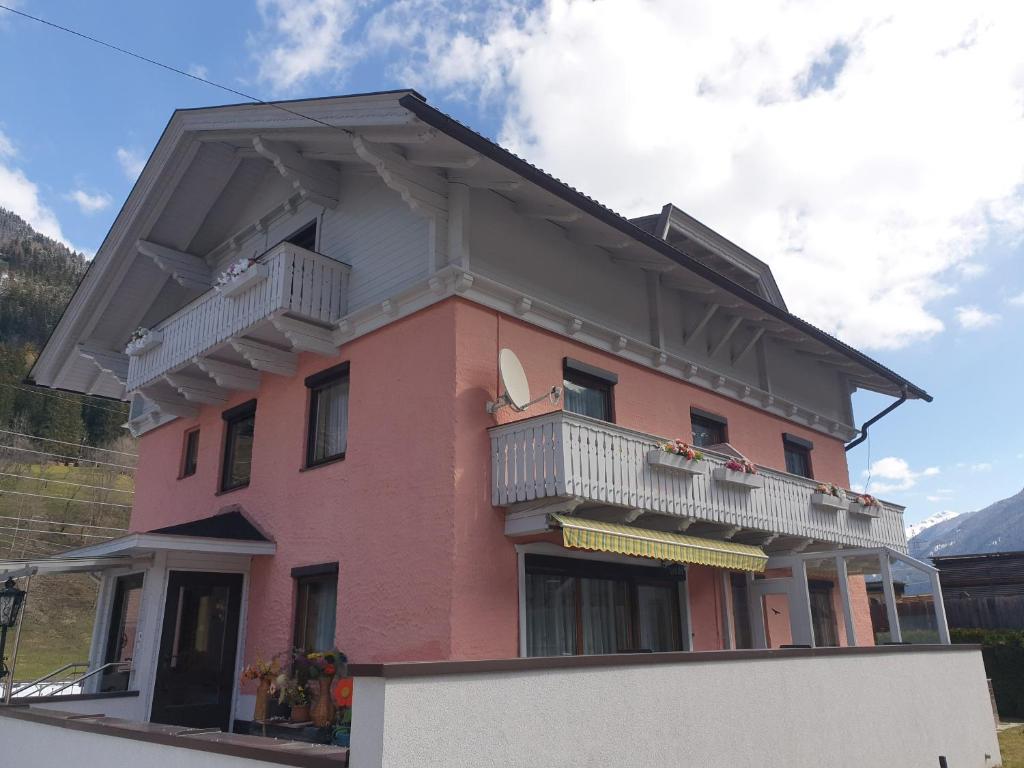 ein rosafarbenes Haus mit Balkon darüber in der Unterkunft Haus Elena in Lainach