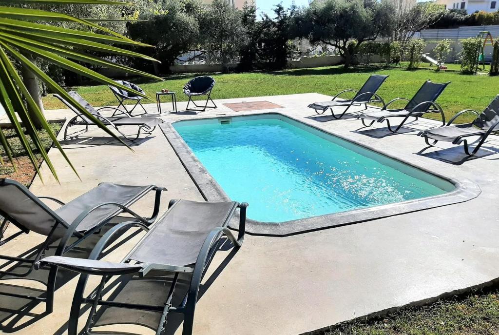 a swimming pool with chairs and a bunch ofitures at Complex Lagonissi Residence with swimming pool. in Lagonissi