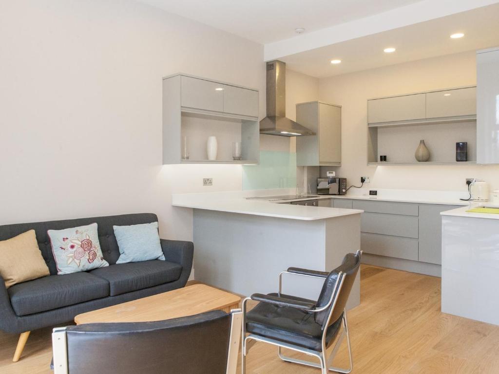 Hotel Spacious & modern flat with Sun Terrace near Greenwich and attractions, a kitchen and living room with a couch and a table at Spacious & modern flat with Sun Terrace near Greenwich and attractions in London