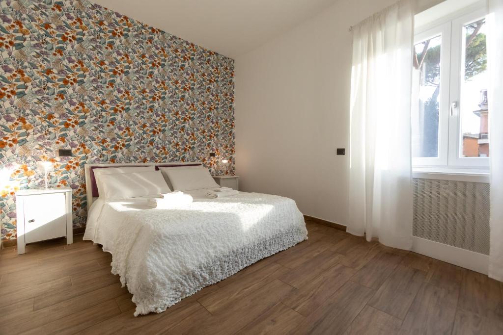 ein Schlafzimmer mit einem Bett und einer Blumenwand in der Unterkunft Comfy Vatican Suite in Rom