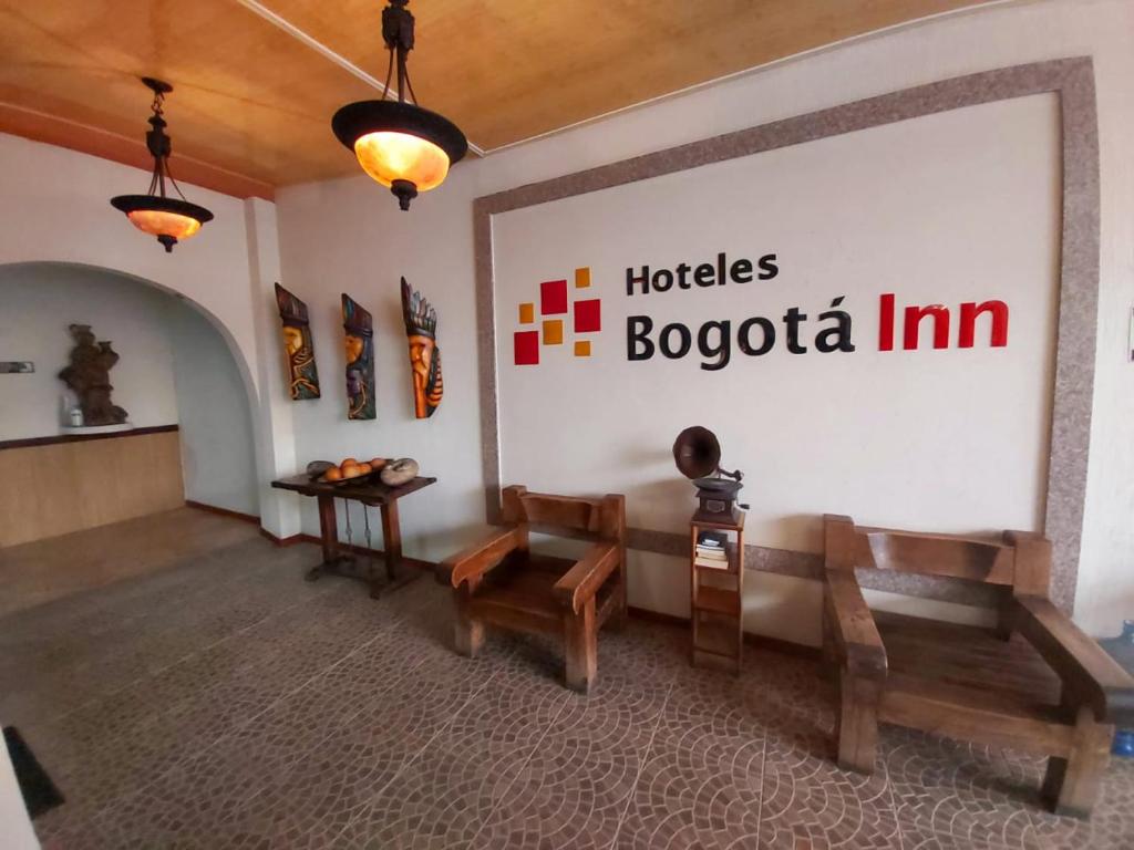 una habitación con bancos y un cartel en la pared en Hoteles Bogotá Inn Turisticas 63, en Bogotá
