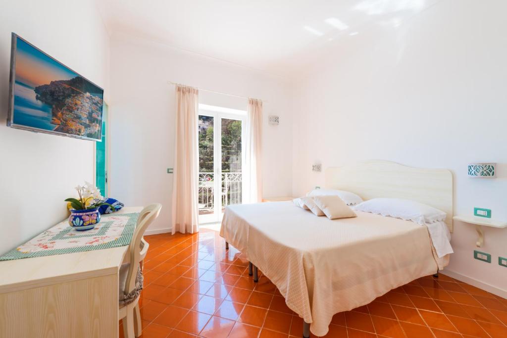 1 dormitorio con 1 cama y 1 mesa en una habitación en Casa Pietro, en Positano