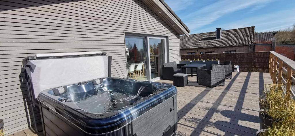 a hot tub on a patio next to a house at Le Walker in Francorchamps