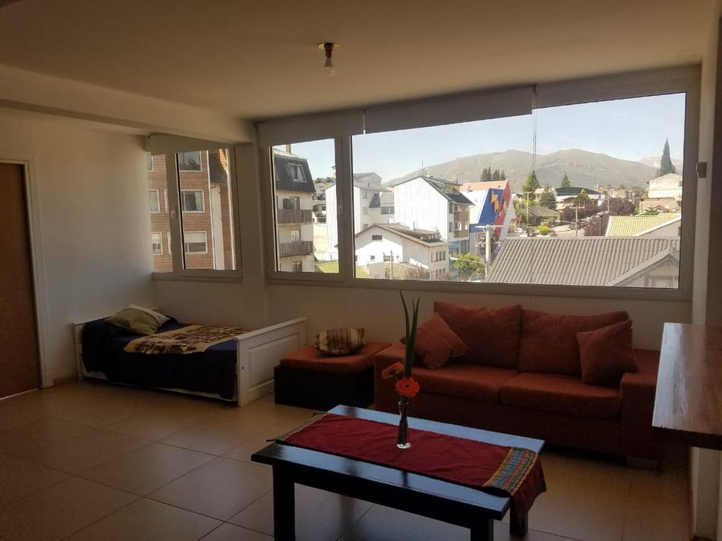 a living room with a couch and a large window at Exclusivo Pi in San Carlos de Bariloche