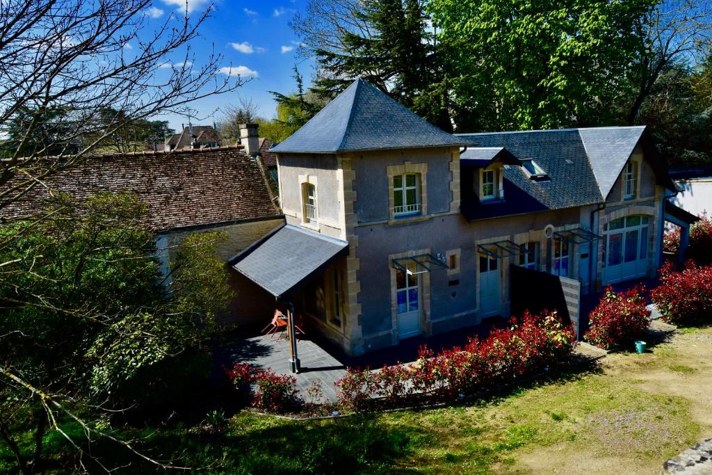une maison avec un toit bleu et quelques fleurs dans l'établissement Le Clos des Marronniers, à Douvres-la-Délivrande