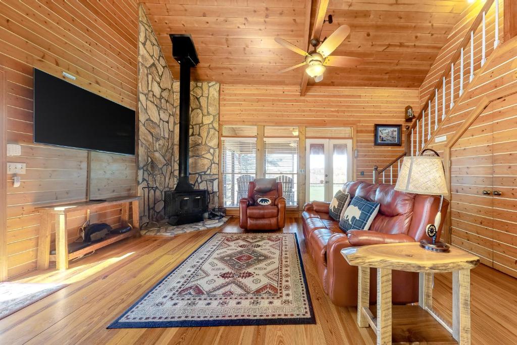 sala de estar con sofá de cuero y chimenea en Down by the River, en Blue Ridge