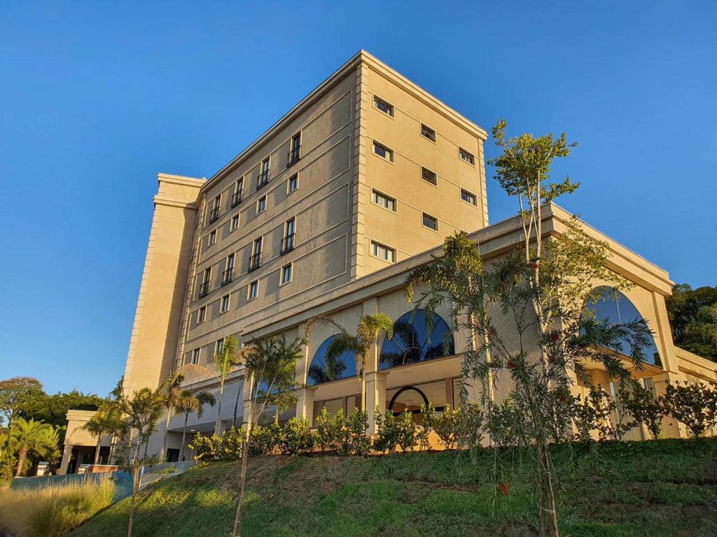 Class Hotel Piracicaba في بيراسيكابا: مبنى كبير أمامه أشجار نخيل