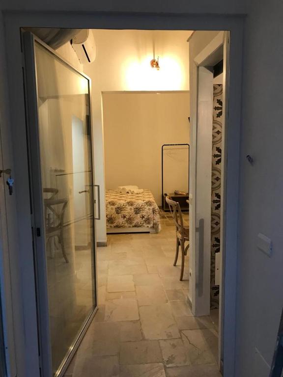 a hallway with a room with a bed and a glass door at Romì-Antica dimora in Polignano a Mare