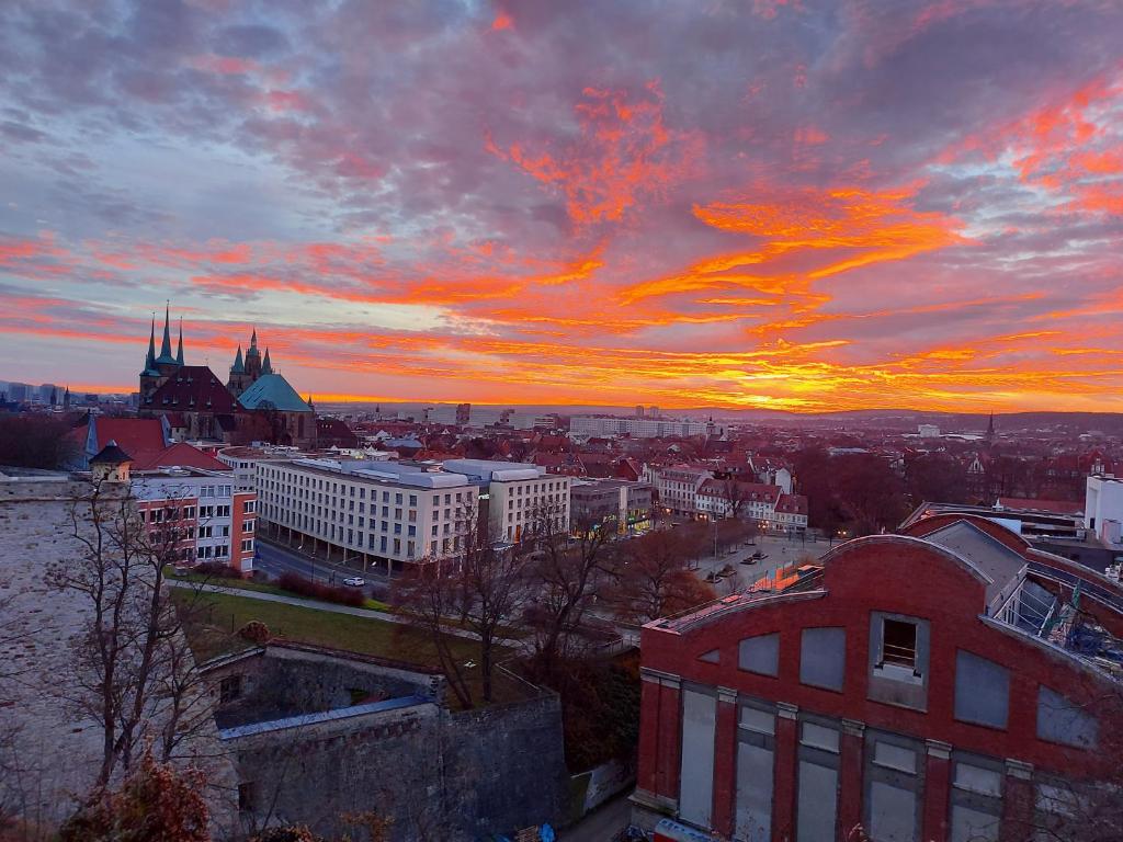 ein Blick auf eine Stadt bei Sonnenuntergang in der Unterkunft AT THE TOP - Penthouse über den Dächern der Stadt in Erfurt