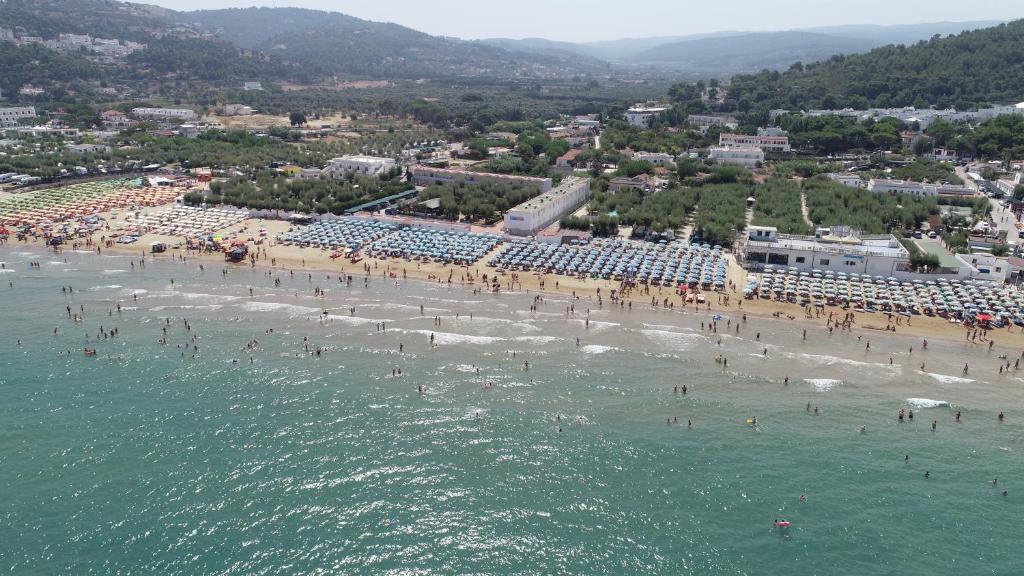 eine Luftansicht auf einen Strand mit Menschen im Wasser in der Unterkunft Village GEMINI in Peschici