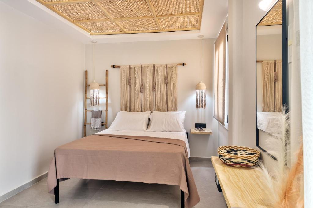 a bedroom with a large bed and a mirror at Aeolia Boutique Studios in Ermoupoli