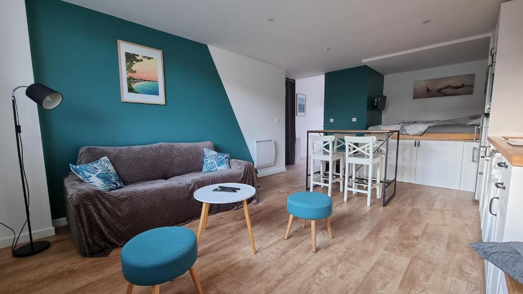 ein Wohnzimmer mit einem Sofa und einem Tisch in der Unterkunft Vacances Ô Loch - Studio à 200 mètres de la plage - Le Cap Coz Fouesnant in Fouesnant