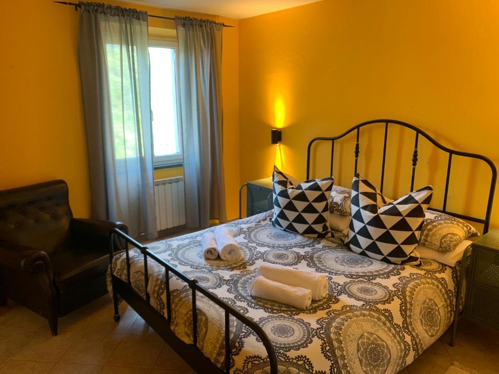 a bedroom with a bed with pillows and a chair at Casa Duke in Corniglia