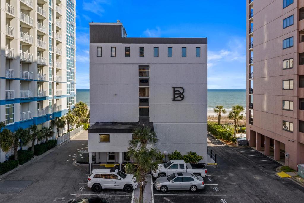 an aerial view of a building with cars parked in a parking lot at The Beverley Beach House in Myrtle Beach