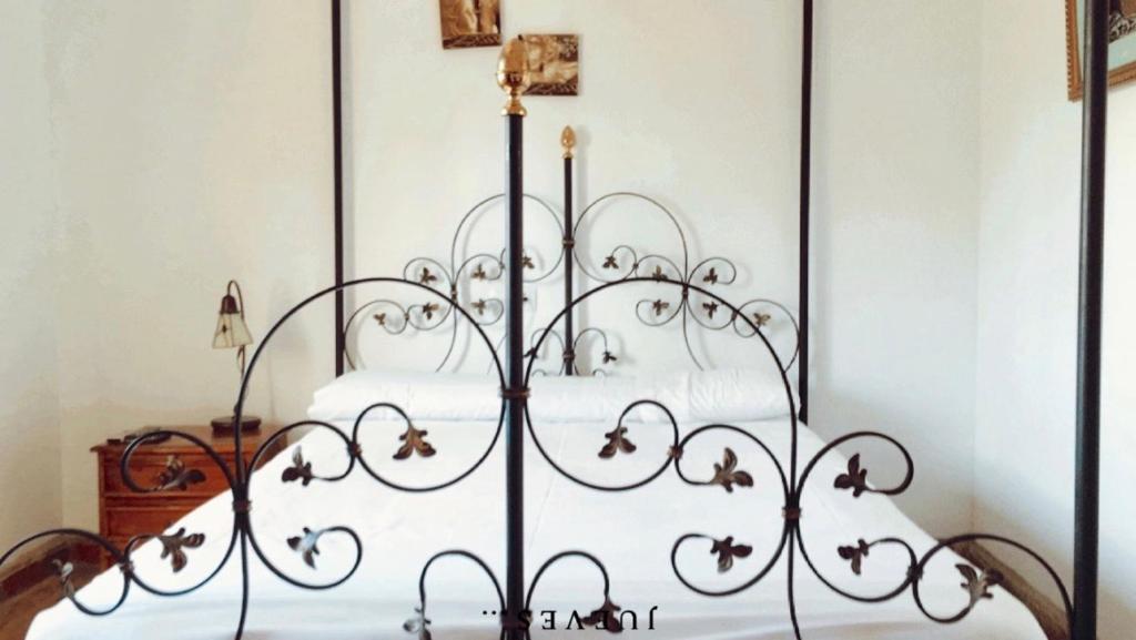 a metal bed with white sheets in a bedroom at La Hacienda del Marquesado in Albuñán