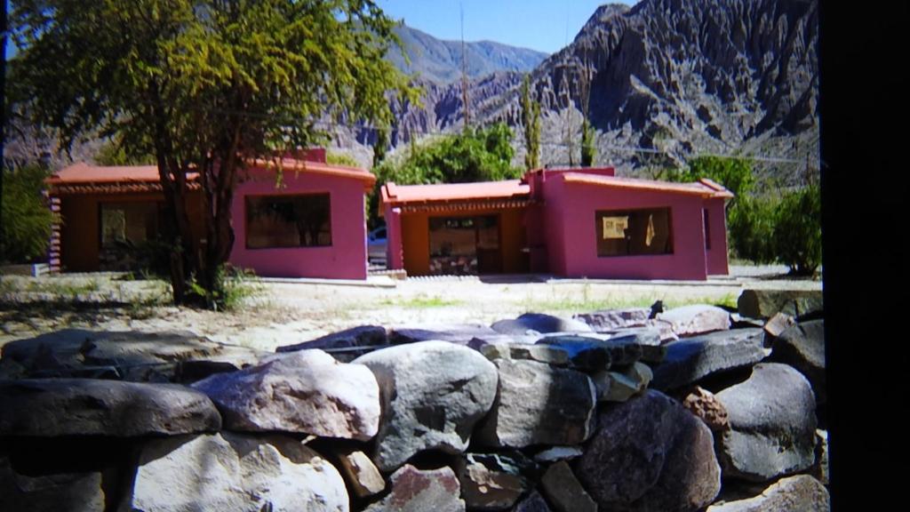 un pequeño edificio con una pared de roca delante de él en Pirca del Abuelo II en Purmamarca