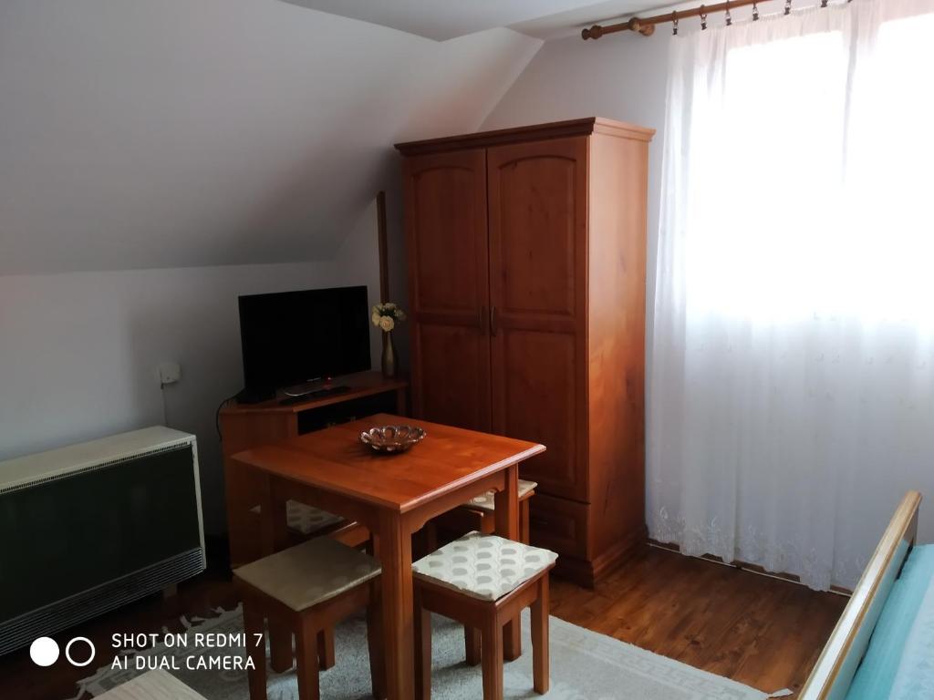 Camera piccola con tavolo in legno e TV di Apartman Ana a Mokra Gora