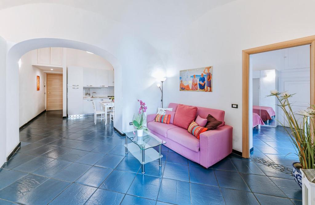 a living room with a pink couch and a table at Ischia Domus in Ischia