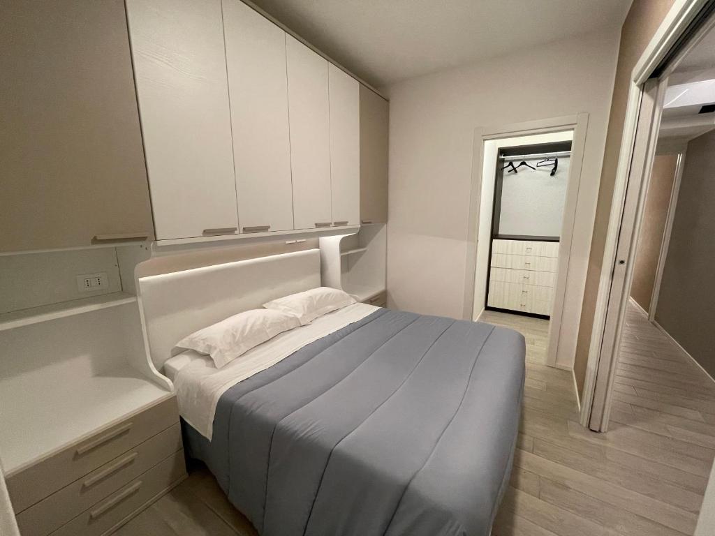 Dormitorio pequeño con cama y armarios blancos en Il Parco di Yuki (4) en Ancona
