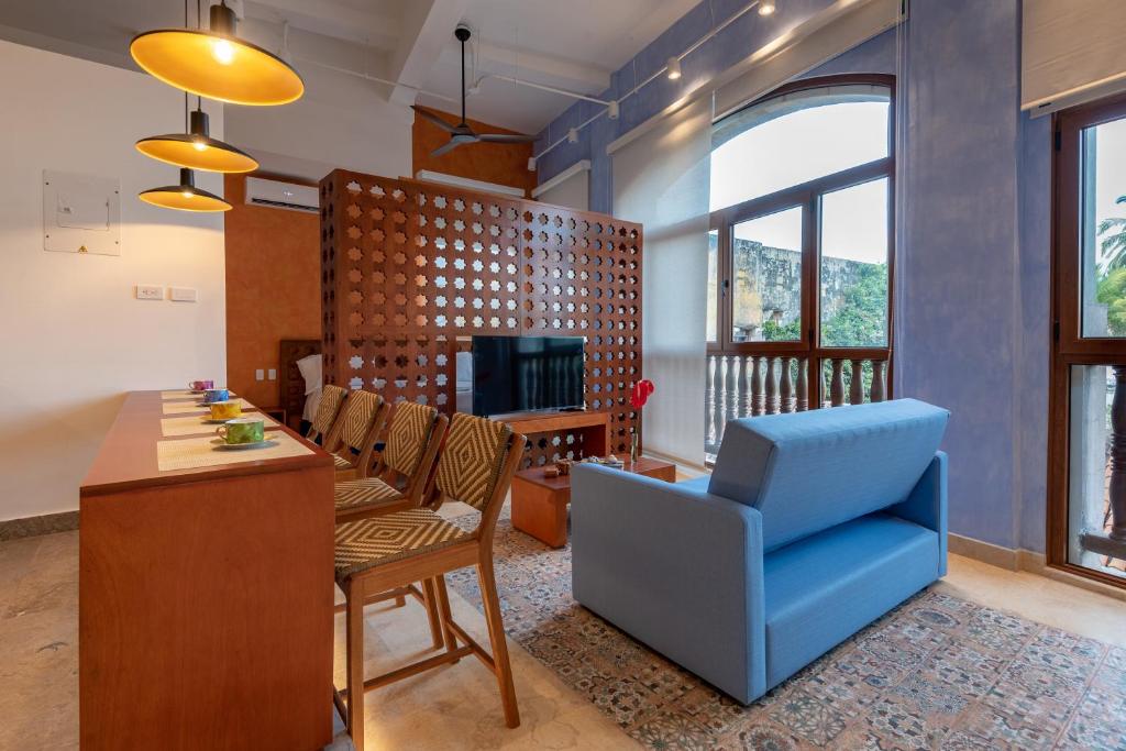 Ganem Suites Cartagena في كارتاهينا دي اندياس: غرفة معيشة مع طاولة وكرسي أزرق