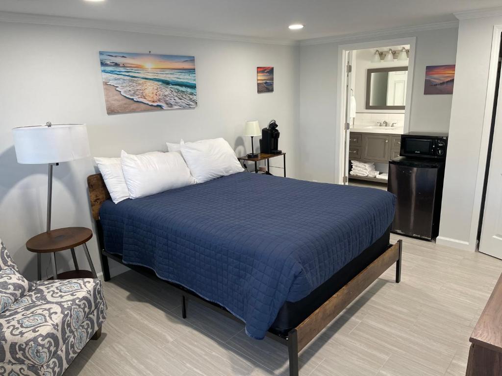 a bedroom with a blue bed and a couch at The Surf Beach Motel in Amelia Island